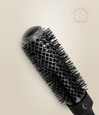 Close-up of a slim HeatSense Round Brush barrel, showing its open end, vents and black bristles.