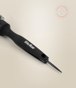 Close-up of the black HeatSense Round Brush handle with its pointed sectioning pin extended.